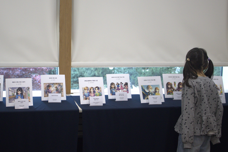 지난 18일 서울 용산구 삼일미래재단 본사에서 초등학생들이 제작한 ‘나만의 AI 동화책’이 전시된 가운데, 한 참가자가 작품들을 둘러보고 있다. 삼일회계법인 제공.
