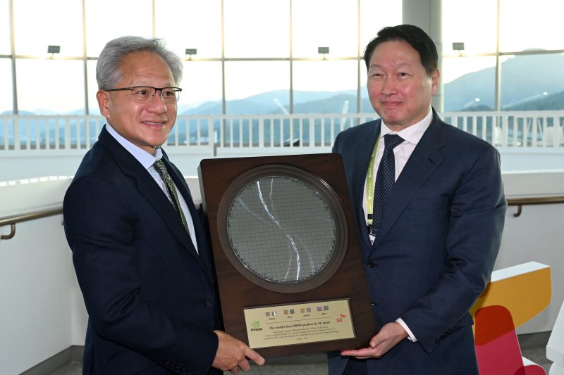[경주=뉴시스] 추상철 기자 = 젠슨 황 엔비디아 CEO가 31일 경북 경주시 경주예술의전당에서 열린 아시아태평양경제협력체(APEC) CEO 서밋에 참석해 최태원 SK그룹 회장 겸 대한상의 회장으로 부터 SK하이닉스의 HBM4 반도체 웨이퍼를 선물로 받고 있다. (공동취재) 2025.10.31. photo@newsis.com