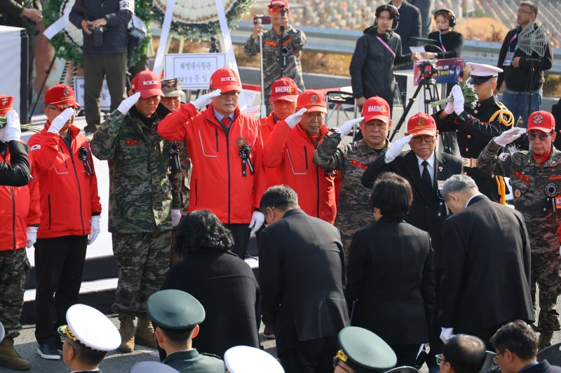 23일 대전 유성구 국립대전현충원에서 거행된 15회 연평도 포격전 전투 영웅 추모 및 전승 기념식에서 해병대 전우회 관계자들이 전투 영웅들의 유족에게 거수경례하고 있다. 연합뉴스