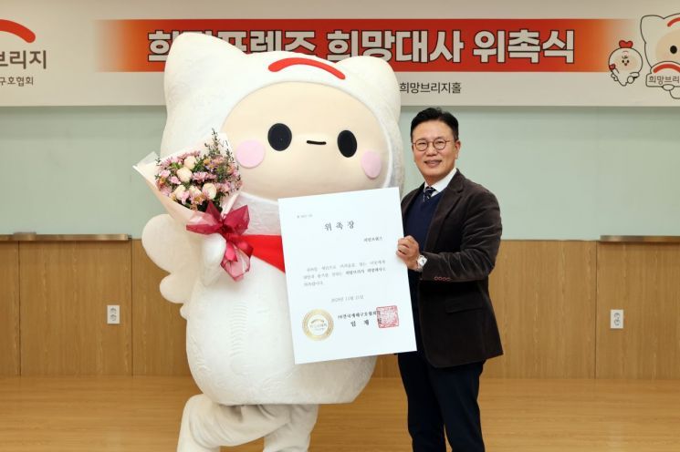 신훈 희망브리지 사무총장이 공식 캐릭터 '희망프렌즈'를 희망대사로 위촉하고 기념촬영을 하고 있다. 희망브리지 제공