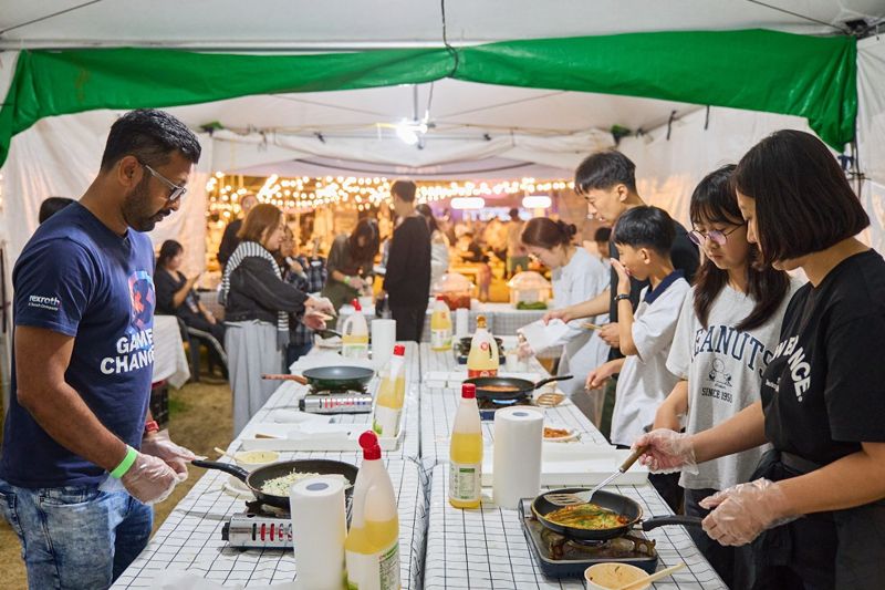 ‘2025 별바다부산 나이트 페스타’ 나이트 마켓 현장에서 국내외 관광객들이 찌짐(전) 만들기 체험을 하고 있는 모습. 부산관광공사 제공