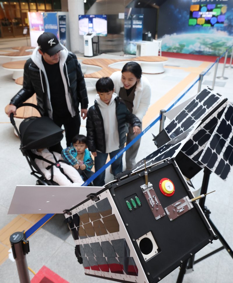 ‘경기기후위성’ 1호기 발사를 하루 앞둔 25일 경기 수원시 영통구 경기신용보증재단 도민쉼터에 마련된 경기기후위성 임시상황실에서 시민들이 '경기기후위성' 모형을 살펴보고 있다. ⓒ News1 김영운 기자