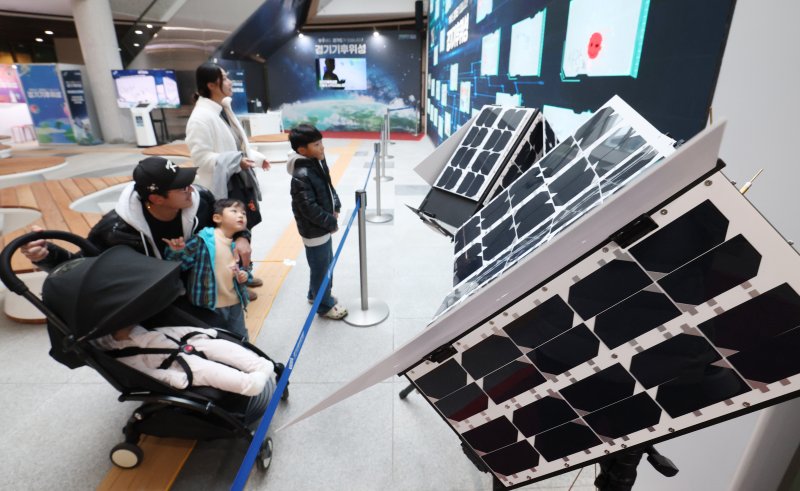 ‘경기기후위성’ 1호기 발사를 하루 앞둔 25일 경기 수원시 영통구 경기신용보증재단 도민쉼터에 마련된 경기기후위성 임시상황실에서 시민들이 '경기기후위성' 모형을 살펴보고 있다. ⓒ News1 김영운 기자