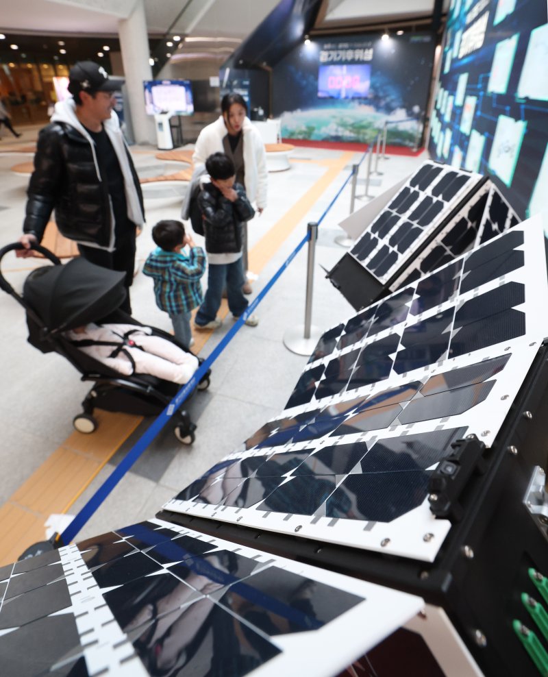 ‘경기기후위성’ 1호기 발사를 하루 앞둔 25일 경기 수원시 영통구 경기신용보증재단 도민쉼터에 마련된 경기기후위성 임시상황실에서 시민들이 '경기기후위성' 모형을 살펴보고 있다. ⓒ News1 김영운 기자