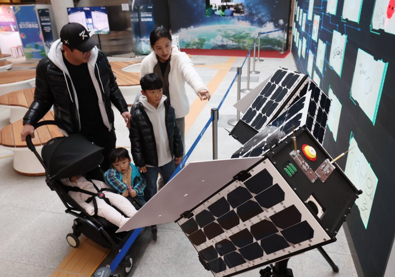 ‘경기기후위성’ 1호기 발사를 하루 앞둔 25일 경기 수원시 영통구 경기신용보증재단 도민쉼터에 마련된 경기기후위성 임시상황실에서 시민들이 '경기기후위성' 모형을 살펴보고 있다. ⓒ News1 김영운 기자