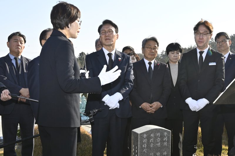 [광주=뉴시스] 박기웅 기자 = 김민석 국무총리가 26일 오후 광주 북구 운정동 국립5·18민주묘지를 방문해 문재학 열사 묘 앞에서 참배한 뒤 해설사의 설명을 듣고 있다. 이날 참배를 마친 김 총리는 기아 오토랜드 광주공장을 시찰, 동천동 골목상권과 1913송정역시장 등을 방문한다. 2025.11.26. pboxer@newsis.com