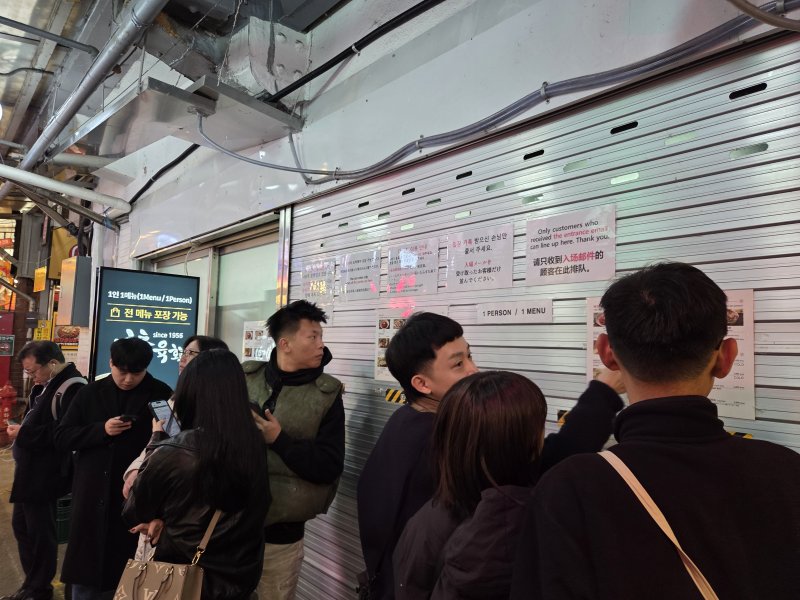 [서울=뉴시스][서울=뉴시스]김윤영 수습기자=26일 오후 12시께 찾은 서울 종로구 광장시장 내 외국인 관광객들이 좁은 통로에서 음식을 먹고 있다. 2025.11.26 photo@newsis.com