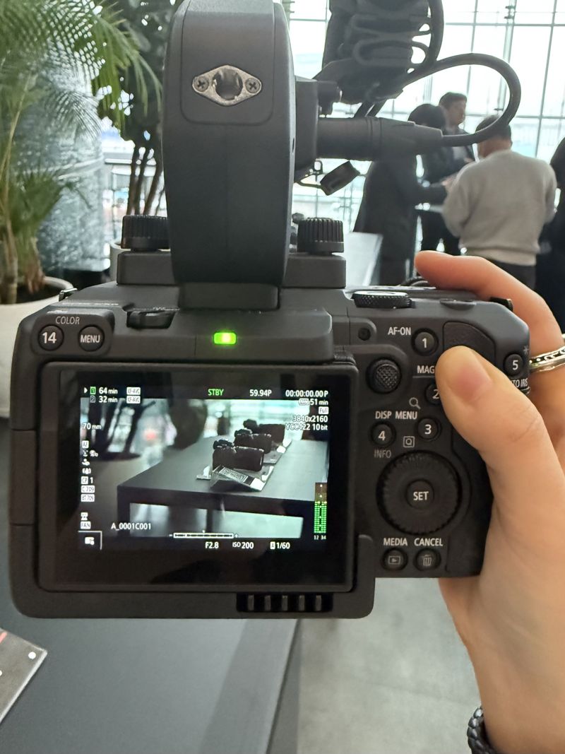 기자가 직접 렌즈, 핸들, 마이크 등이 모두 장착된 EOS C50을 한 손으로 직접 들어보고 있다. 사진=최혜림 기자