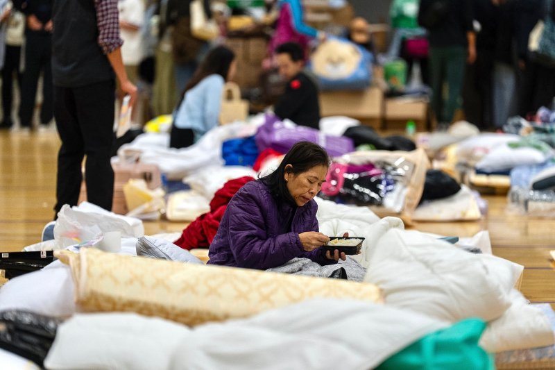 Resident rests at a temporary shelter near the fire scene at Wang Fuk Court, a residential estate in the Tai Po district of Hong Kong's New Territories, Thursday, Nov. 27, 2025. (AP Photo/Chan Long Hei)