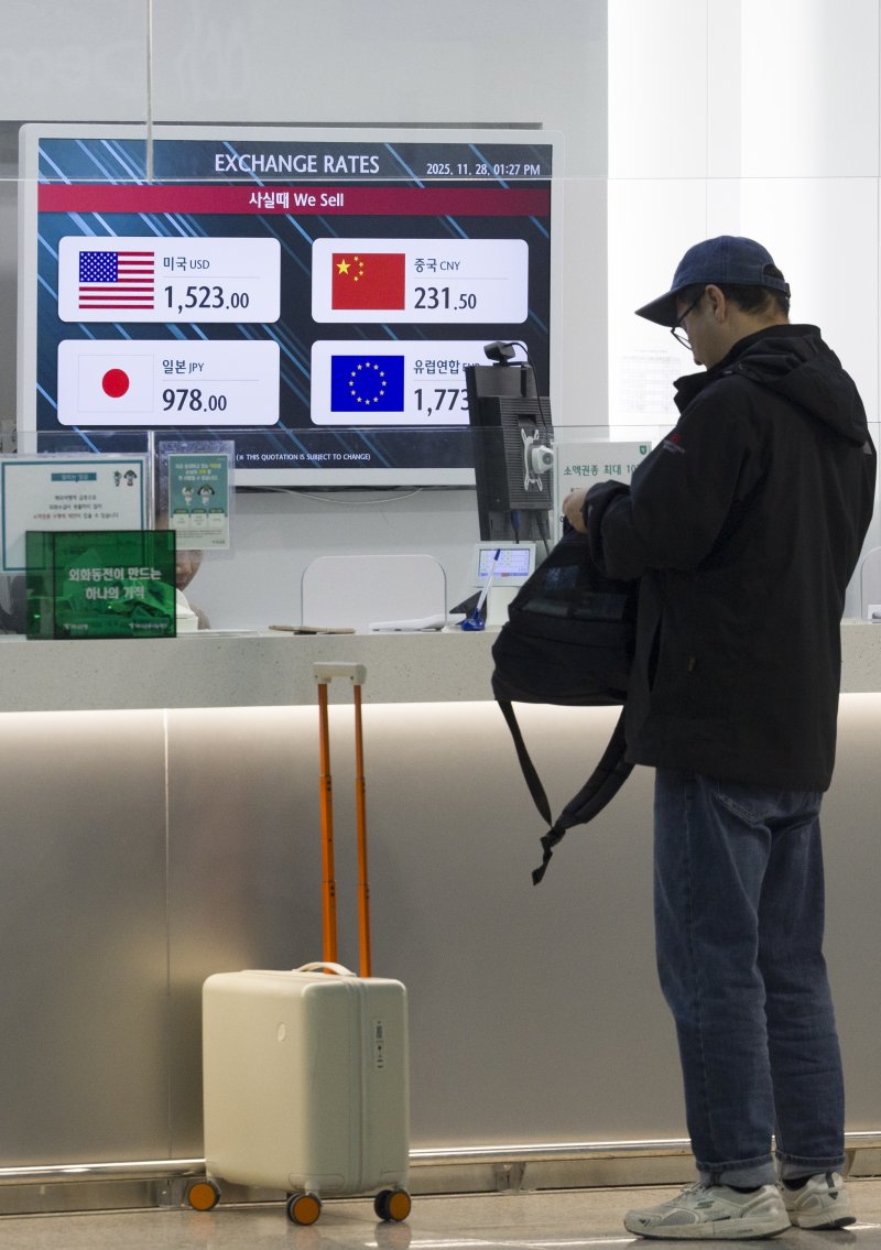 [인천공항=뉴시스] 김근수 기자 = 고환율이 계속되는 28일 인천 중구 인천국제공항 제1여객터미널 은행 환전소에서 여행객이 환전을 하고 있다. 2025.11.28. ks@newsis.com