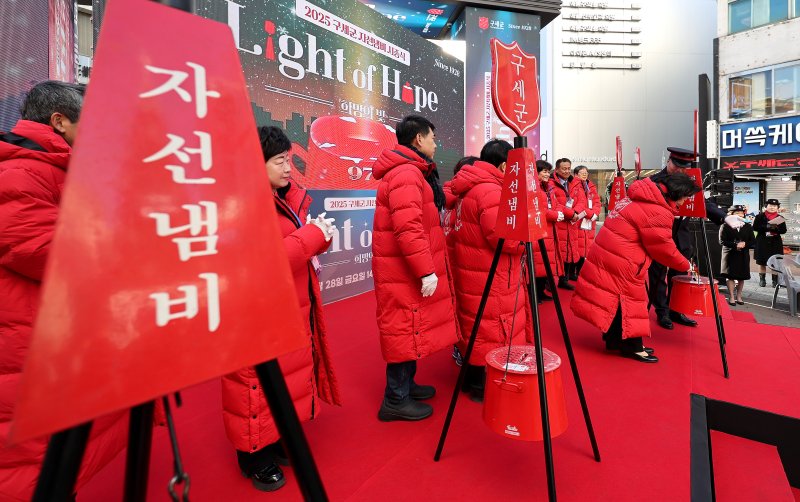 [대구=뉴시스] 이무열 기자 = 28일 대구 중구 동성로 28아트스퀘어 앞에서 열린 2025 구세군 자선냄비 시종식에서 참석자들이 자선냄비에 봉투를 넣고 있다. 2025.11.28. lmy@newsis.com