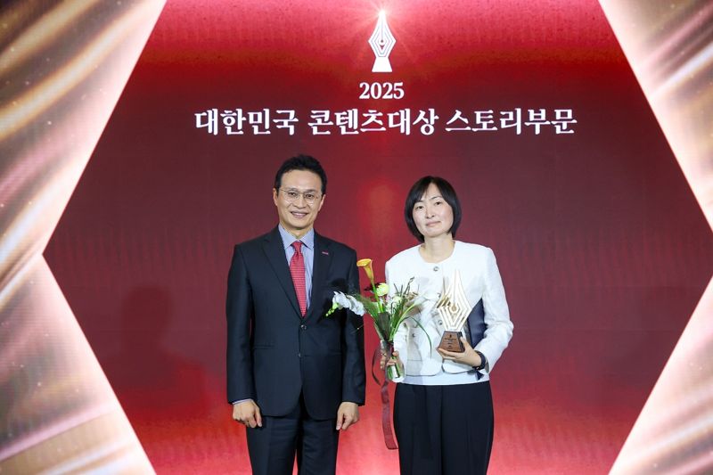 한국콘텐츠진흥원의 유현석 원장직무대행과 기념 촬영하고 있는 이유미 작가(오른쪽). 콘진원 제공