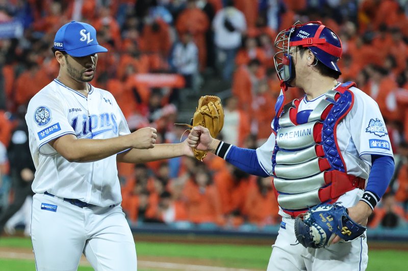 [대구=뉴시스] 이무열 기자 = 22일 대구 수성구 삼성라이온즈파크에서 열린 2025 신한 SOL 뱅크 KBO 포스트시즌 플레이오프 4차전 한화 이글스와 삼성 라이온즈의 경기, 7회초 2사 주자 2,3루 상황에서 삼성 가라비토가 한화 문현빈을 플라이아웃 시킨 뒤 더그아웃에 들어서며 포수 강민호와 기뻐하고 있다. 2025.10.22. lmy@newsis.com