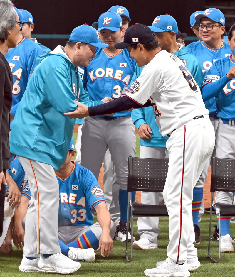 [키타히로시마=뉴시스] 사진공동취재단 = 30일 오후(현지 시간) 일본 홋카이도 키타히로시마시 에스콘필드 홋카이도에서 열린 '한일 드림 플레이어즈 게임'에서 경기를 마친 양팀이 기념촬영을 하기위해 모이자 일본 하라 감독이 한국 김인식 감독을 부축하고 있다. 이 게임은 한국과 일본 프로야구를 대표했던 스타들이 총 출동해 양국의 우정을 이어가는 경기다. 2025.11.30. photo@newsis.com