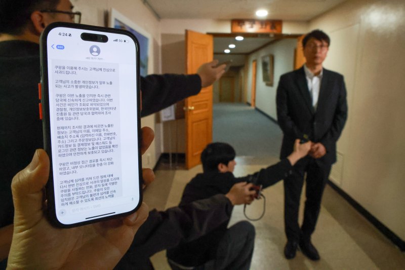 박대준 쿠팡 대표이사가 지난달 30일 오후 서울 종로구 정부서울청사에서 열린 쿠팡 개인정보 유출 관련 긴급 관계부처 장관회의에 참석한 뒤 이용자들을 향해 사과 발언하고 있다. 왼쪽은 쿠팡이 고객들에게 보낸 개인정보 유출안내 문자. (공동취재) 2025.11.30/뉴스1 ⓒ News1 장수영 기자