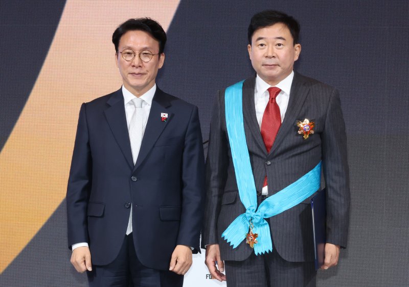 [서울=뉴시스] 김명원 기자 = 김민석 국무총리가 1일 오전 서울 중구 소공동 롯데호텔에서 열린 제11회 중견기업인의 날 기념식에서 이동현 오상헬스케어 회장에게 금탑산업훈장을 수여한 후 기념촬영을 하고 있다. 2025.12.01. kmx1105@newsis.com