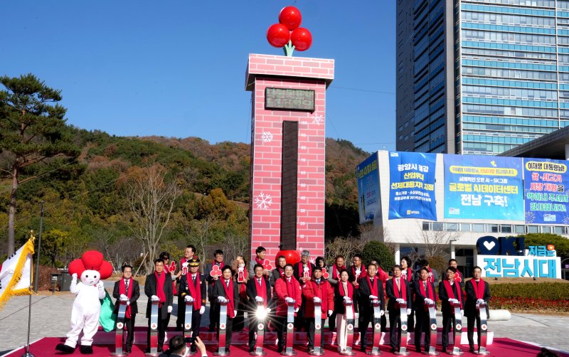 [무안=뉴시스] 김영록 전남지사가 1일 도청 광장 앞 희망 2026 나눔캠페인 출범식 및 사랑의 온도탑 제막식에서 다른 참석자들과 사랑의 온도 올리기 퍼포먼스를 하고 있다. (사진 = 전남도 제공). 2025.12.01. photo@newsis.com *재판매 및 DB 금지