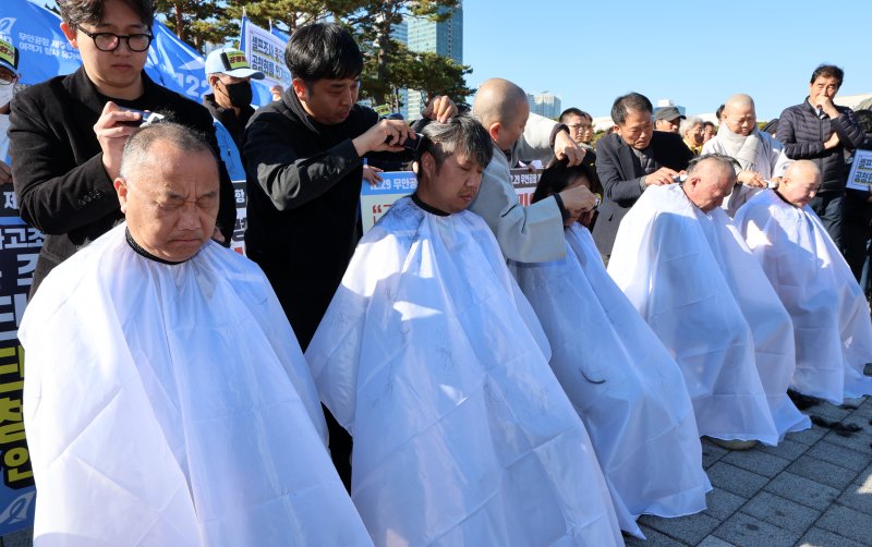 [서울=뉴시스] 이영환 기자 = 12.29 무안공항 제주항공 여객기참사 유가족들이 1일 오후 서울 용산구 대통령실 인근에서 열린 12.29 무안공항 제주항공 여객기참사 유가족협의회·시민사회 긴급 기자회견에서 삭발식을 하고 있다. 2025.12.01. 20hwan@newsis.com