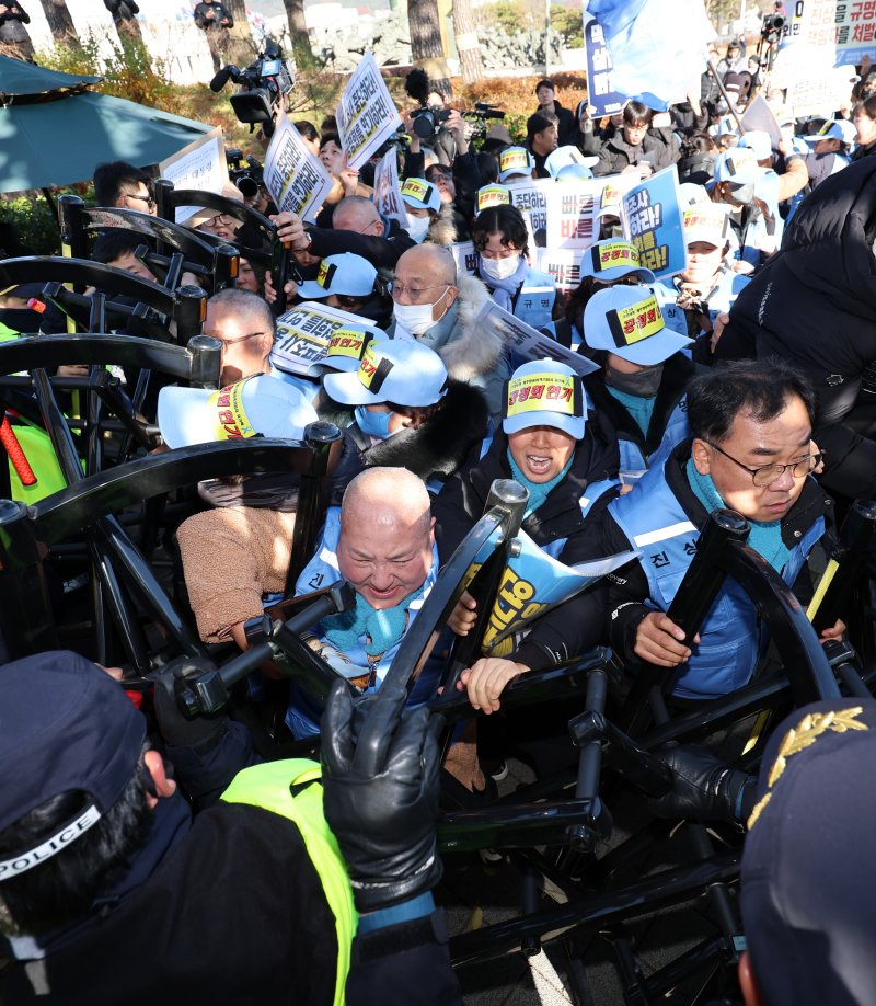 [서울=뉴시스] 이영환 기자 = 김유진 12.29 무안공항 제주항공 여객기참사 유가족협의회 대표와 유가족 등이 1일 오후 서울 용산구 대통령실 인근에서 열린 12.29 무안공항 제주항공 여객기참사 유가족협의회·시민사회 긴급 기자회견을 마친 후 이재명 대통령 면담 요청서 제출을 위해 이동하자 경찰이 막아서고 있다. 2025.12.01. 20hwan@newsis.com