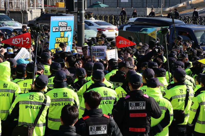 [서울=뉴시스] 이영환 기자 = 김유진 12.29 무안공항 제주항공 여객기참사 유가족협의회 대표와 유가족 등이 1일 오후 서울 용산구 대통령실 인근에서 열린 12.29 무안공항 제주항공 여객기참사 유가족협의회·시민사회 긴급 기자회견을 마친 후 이재명 대통령 면담 요청서 제출을 위해 이동하자 경찰이 막아서고 있다. 2025.12.01. 20hwan@newsis.com