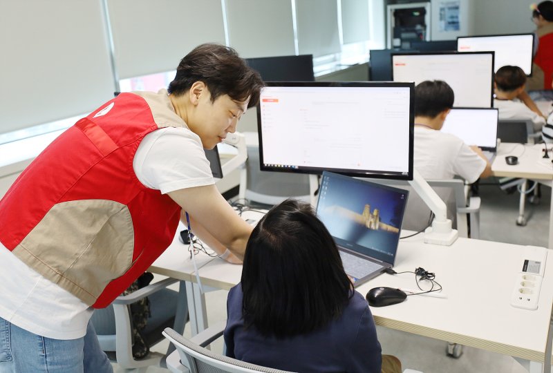 롯데이노베이트 IT 서포터즈(왼쪽 첫번째)가 서울 금천구 취약계층 및 다문화 자녀 대상 AI 활용 교육 봉사활동을 하고 있다.