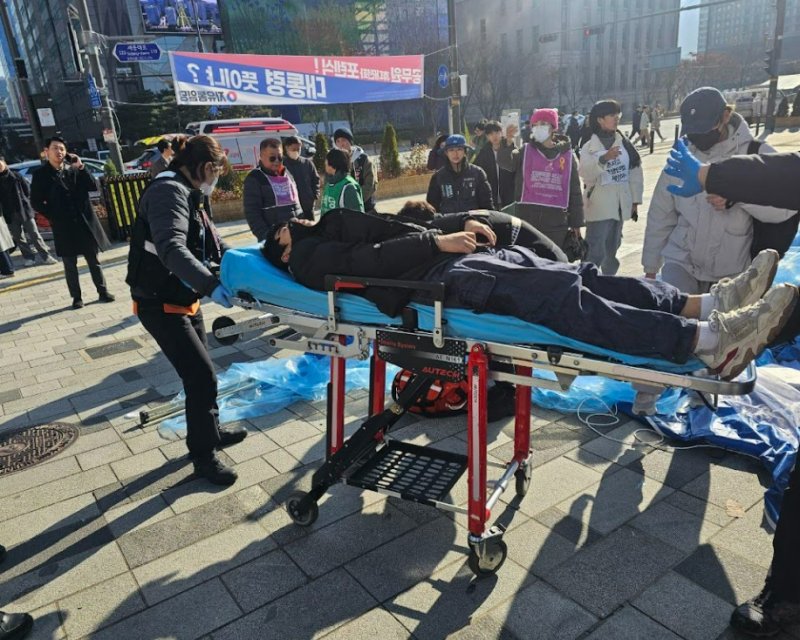 [서울=뉴시스] 전날(1일) 서울 중구 시의회 인근 도시건축전시관 앞 학생인권조례 폐지 반대 농성장이 강제철거된 뒤 부상자가 들것에 실려 이송되고 있다. (사진=아수나로 제공) 2025.12.02. photo@newsis.com