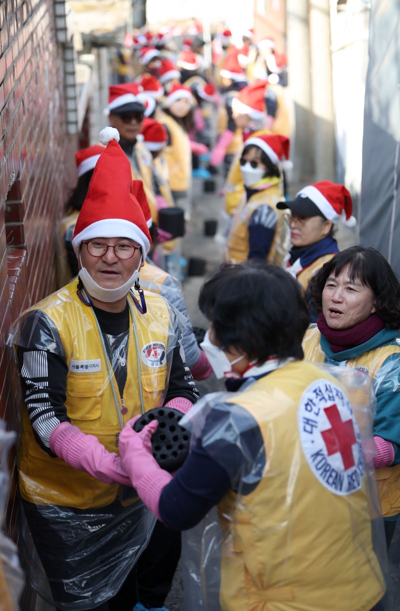 [서울=뉴시스] 김선웅 기자 = 적십자 봉사원·고려아연 임직원들이 2일 서울 노원구 상계동에서 연탄 나눔 봉사활동을 하고 있다. 2025.12.02. mangusta@newsis.com