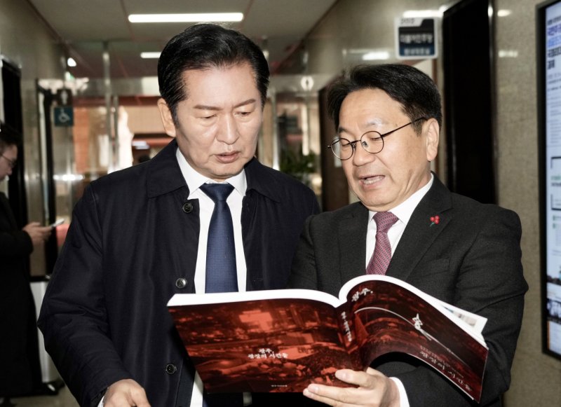 [광주=뉴시스] 강기정 광주시장이 2일 국회 의원회관에서 정청래 더불어민주당 대표에게 12·3 비상계엄 광주의 행동이 담긴 '광주, 광장의 시간들'을 전달하고 있다. (사진=광주시청 제공). photo@newsis.com *재판매 및 DB 금지