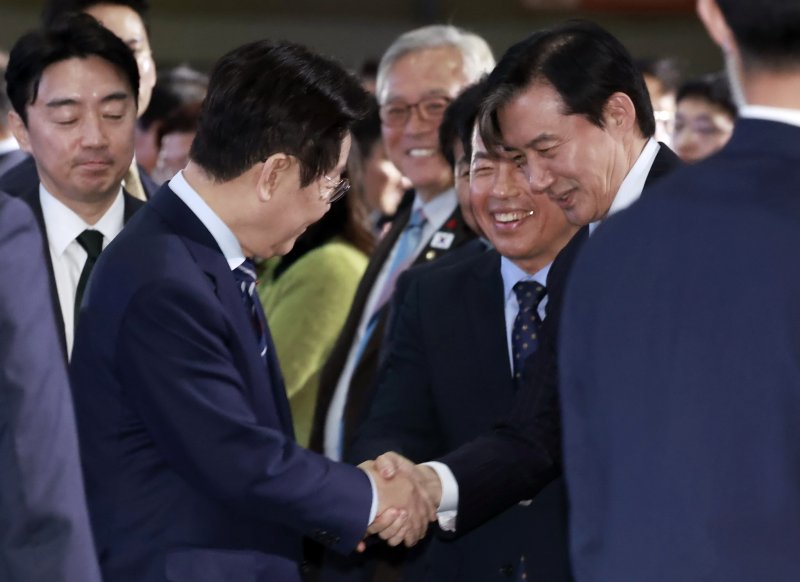 [고양=뉴시스] 최동준 기자 = 이재명 대통령이 2일 경기 고양시 킨텍스에서 열린 제22기 민주평화통일자문회의 출범회의에 입장하며 조국 조국혁신당 대표와 악수하고 있다. 2025.12.02. photocdj@newsis.com