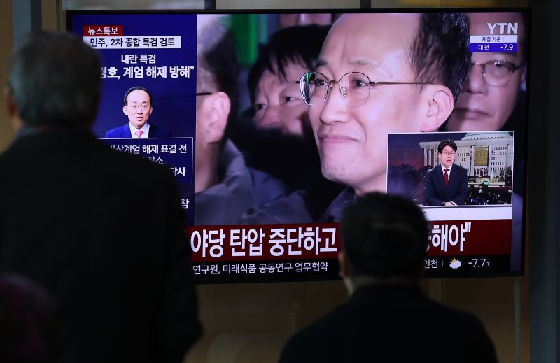 12·3 비상계엄 1년을 맞은 3일 오전 서울 중구 서울역 대합실에서 시민들이 비상계엄 해제 표결 참여를 방해한 혐의를 받는 추경호 국민의힘 의원의 구속영장 기각 관련 뉴스를 지켜보고 있다. 2025.12.3/뉴스1 ⓒ News1 오대일 기자