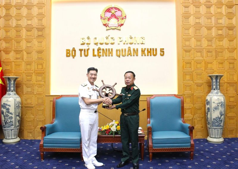 대한민국 해군 순항훈련전단장 홍상용 제독(왼쪽)이 베트남 국방부 군구5 사령부 응우옌 꾸억 흐엉 부사령관으로부터 기념품을 전달받고 있다. 베트남 다낭시 제