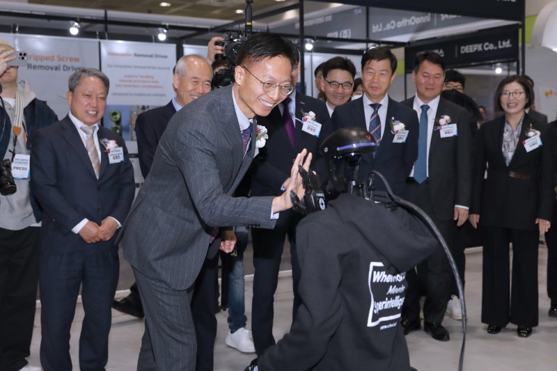 김용선 지식재산처장이 인공지능(AI) 특별 기획관에서 휴머노이드 로봇과 하이파이브를 하고 있다.(지식재산처 제공.재판매 및 DB금지)/뉴스1