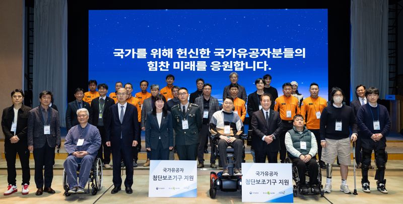 포스코1%나눔재단이 3일 서울 강남구 포스코센터에서 국가유공자 및 현직 소방관·군인 등 36명에게 첨단보조기구를 전달하고 기념사진을 찍고 있다.