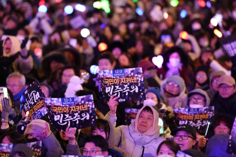 12·3 비상계엄 1년을 맞은 3일 서울 여의도 국회 앞에서 열린 '12·3 내란외환 청산과 종식, 사회대개혁 시민대행진'에 참석한 시민들이 손팻말과 응원봉을 들고 있다. 2025.12.3/뉴스1 ⓒ News1 황기선 기자