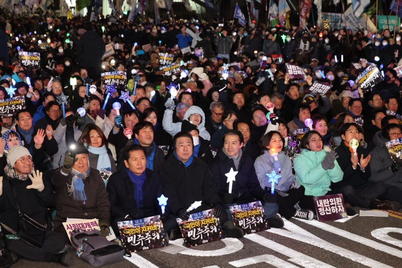 정청래 더불어민주당 대표(앞줄 왼쪽 세번째부터), 김병기 원내대표, 조국 조국혁신당 대표, 김재연 진보당 상임대표, 용혜인 기본소득당 대표, 한창민 사회민주당 대표가 12·3 비상계엄 1년을 맞은 3일 서울 여의도 국회 앞에서 열린 '12·3 내란외환 청산과 종식, 사회대개혁 시민대행진'에 참석해 응원봉을 흔들고 있다. 2025.12.3/뉴스1 ⓒ News1 박지혜 기자