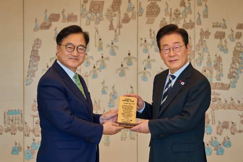 이재명 대통령이 3일 서울 용산 대통령실 청사에서 열린 5부 요인 초청 오찬에서 우원식 국회의장에게 12·3 계엄 당시 파손된 국회사무처 집기들을 재활용해 제작한 '기억패'를 선물 받고 있다. (대통령실 제공. 재판매 및 DB 금지) 2025.12.3/뉴스1 ⓒ News1 이재명 기자