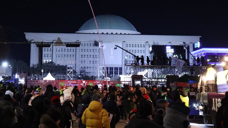 (서울=뉴스1) 박지혜 기자 = 12·3 비상계엄 1년을 맞은 3일 서울 여의도 국회 앞에서 '12·3 내란외환 청산과 종식, 사회대개혁 시민대행진'이 열린 가운데 국회 본청에 촛불 그림의 미디어 파사드가 나오고 있다. 2025.12.3/뉴스1 /사진=뉴스1화상