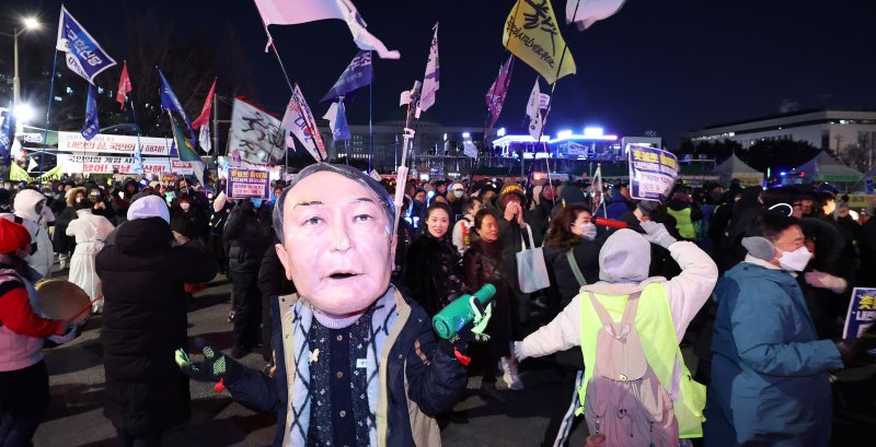 12·3 비상계엄 1년을 맞은 3일 서울 여의도 국회 앞에서 열린 '12·3 내란외환 청산과 종식, 사회대개혁 시민대행진'에서 윤석열 전 대통령 가면을 쓴 시민이 행진하고 있다. 2025.12.3/뉴스1 ⓒ News1 박지혜 기자