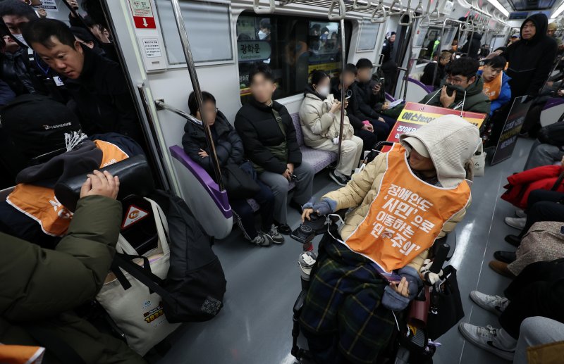 [서울=뉴시스] 이영환 기자 = 전국장애인차별철폐연대(전장연) 회원들이 4일 오전 서울 종로구 지하철5호선 광화문역에서 열린 '제67차 출근길 지하철 탑니다’ 시위에 참석하기 위해 5호선에 탑승해 광화문역에 도착하고 있다. 2025.12.04. 20hwan@newsis.com