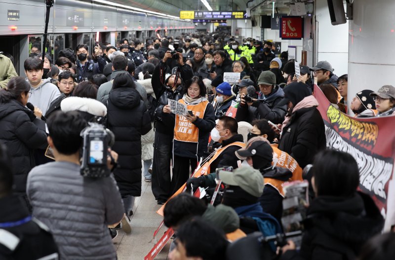 [서울=뉴시스] 이영환 기자 = 4일 오전 서울 종로구 지하철5호선 광화문역에서 '제67차 출근길 지하철 탑니다’ 시위가 진행중인 가운데 출근길 시민들이 이동하고 있다. 2025.12.04. 20hwan@newsis.com