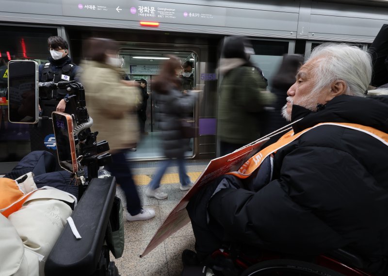 [서울=뉴시스] 이영환 기자 = 박경석 전국장애인차별철폐연대(전장연) 상임공동대표가 4일 오전 서울 종로구 지하철5호선 광화문역에서 열린 '제67차 출근길 지하철 탑니다’ 시위에 참석해 출근길 시민들을 바라보고 있다. 2025.12.04. 20hwan@newsis.com