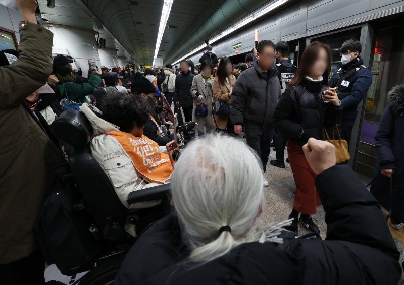[서울=뉴시스] 이영환 기자 = 4일 오전 서울 종로구 지하철5호선 광화문역에서 '제67차 출근길 지하철 탑니다’ 시위가 진행중인 가운데 출근길 시민들이 이동하고 있다. 2025.12.04. 20hwan@newsis.com