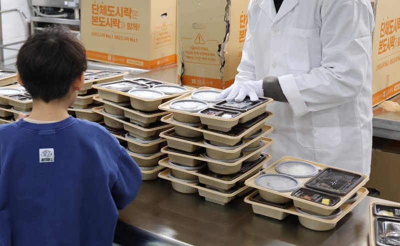 학교 급식·돌봄 업무 등에 종사하는 비정규직 노동자들이 총파업에 돌입한 4일 대전의 한 초등학교에서 어린이들이 도시락을 받고 있다. 2025.12.4/뉴스1 ⓒ News1 김기태 기자