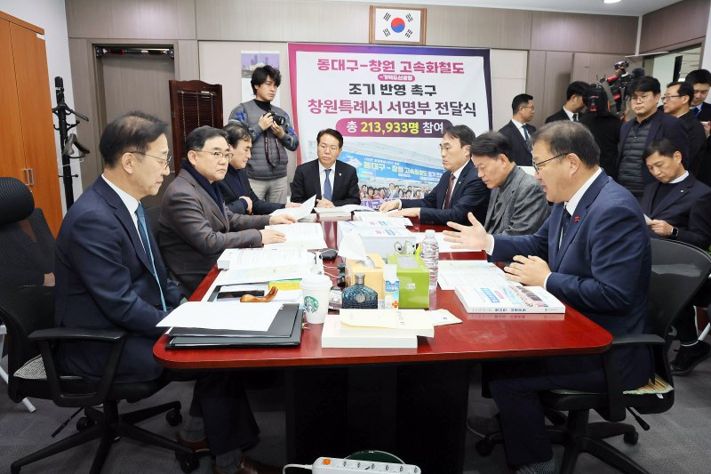 [창원=뉴시스] 강경국 기자 = 장금용 경남 창원시장 권한대행과 김종양, 허성무, 윤한홍, 이종욱 국회의원, 김응수 창원상공회의소 상근부회장, 이동찬 국립창원대학교 사무국장이 4일 김윤덕 국토교통부 장관에게 '동대구-창원-가덕도신공항 고속화철도 조기 반영 촉구' 서명부를 전달하고 있다. (사진=창원시청 제공). 2025.12.04. photo@newsis.com *재판매 및 DB 금지