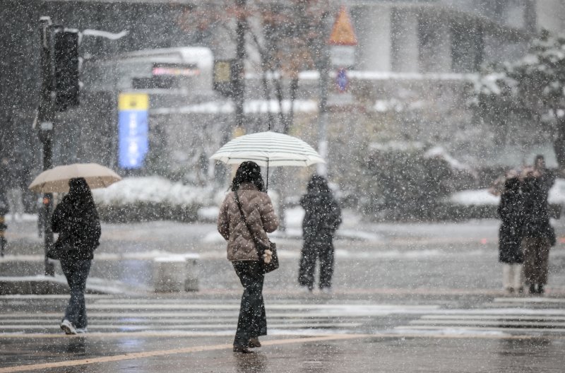 [서울=뉴시스] 정병혁 기자 = 27일 서울 용산구 용산역 인근에서 우산을 쓴 시민들이 눈을 맞으며 이동하고 있다. 2024.11.27. jhope@newsis.com
