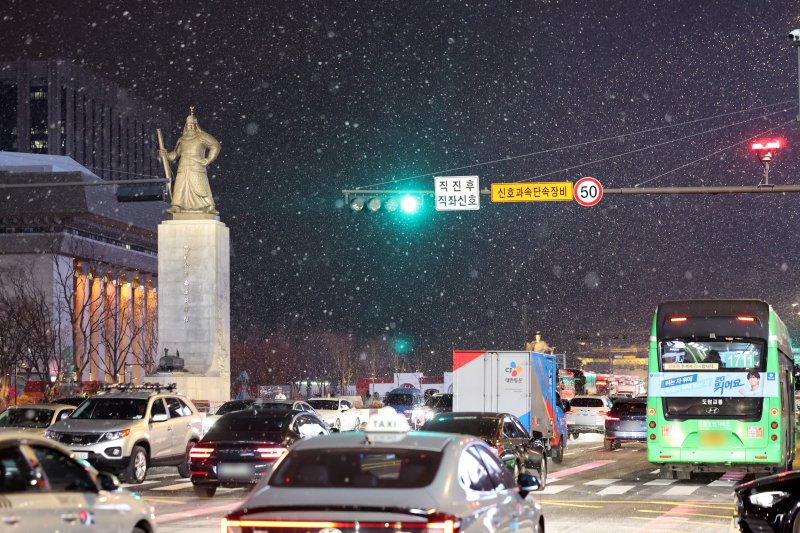 첫눈이 내린 4일 오후 서울 광화문 네거리에서 퇴근길 차량들이 도로를 달리고 있다. 뉴스1