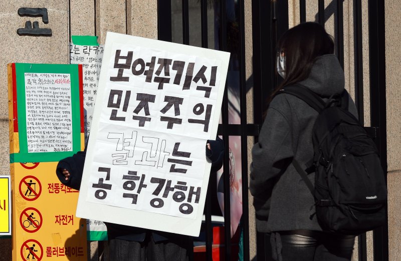 4일 성북구 동덕여자대학교에서 한 학생이 공학반대 1인시위를 하고 있다. 동덕여자대학교와 학생들은 이날 캠퍼스 건물 공학 반대 항의 래커 제거 행사와 공학전환 강행 반대 시위를 각각 계획예정이었으나 동덕여대를 겨냥한 흉기난동 예고 글이 인터넷에 올라오면서 두 일정을 잠정 연기했다. 2025.12.4/뉴스1 ⓒ News1 이호윤 기자