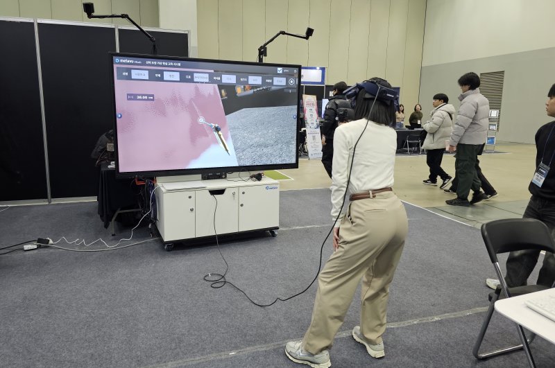 4일 오전 벡스코 제2전시장에서 열린 'K-하이테크 미래혁신 박람회' 현장. HD현대중공업 신기술 체험관에서 한 참여자가 VR 활용 선박도장 작업교육 프로그램 'Metavu Vrush'를 체험해 보고 있다. 사진=변옥환 기자