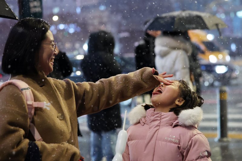 첫눈이 내린 4일 오후 서울 광화문 네거리에서 어린이가 첫눈을 맛보고 있다. 2025.12.4/뉴스1 ⓒ News1 황기선 기자