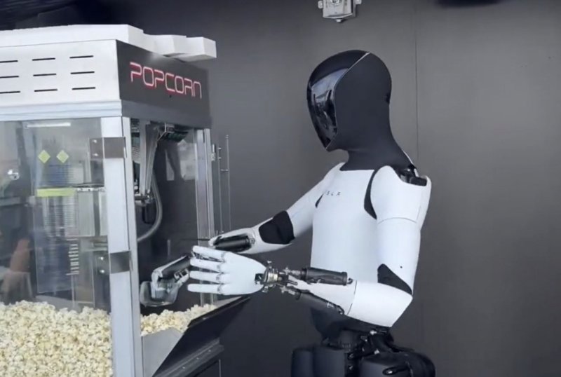 [서울=뉴시스] 테슬라가 개발 중인 휴머노이드 로봇 '옵티머스'가 팝콘 부스에서 손님들을 맞이하는 모습. (사진=LA타임즈 갈무리) 2025.07.23 *재판매 및 DB 금지